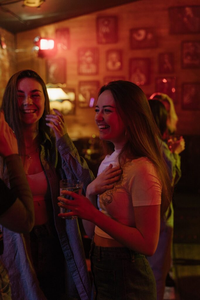 Guests in conversation at a bar with warm lighting